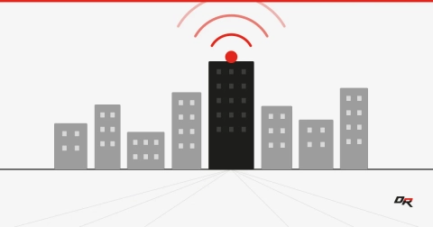 Flat vector graphic of gray campus buildings with a central black building emitting red wireless signal arcs, over faint perspective lines — copper campus infrastructure moving to wireless.