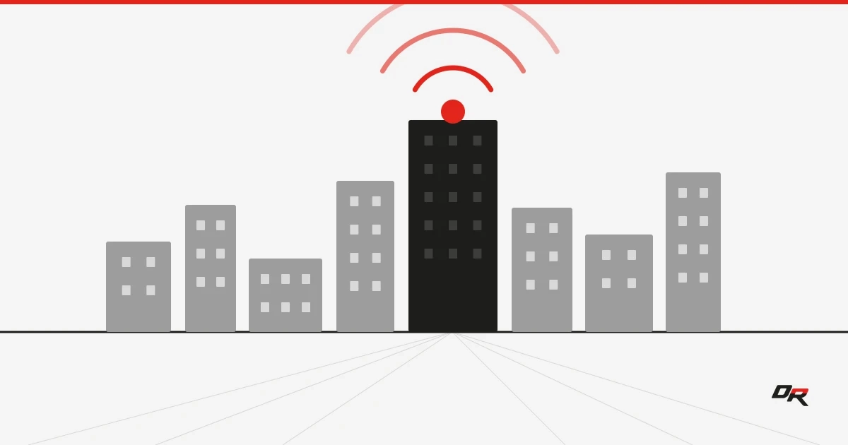 Flat vector graphic of gray campus buildings with a central black building emitting red wireless signal arcs, over faint perspective lines — copper campus infrastructure moving to wireless.